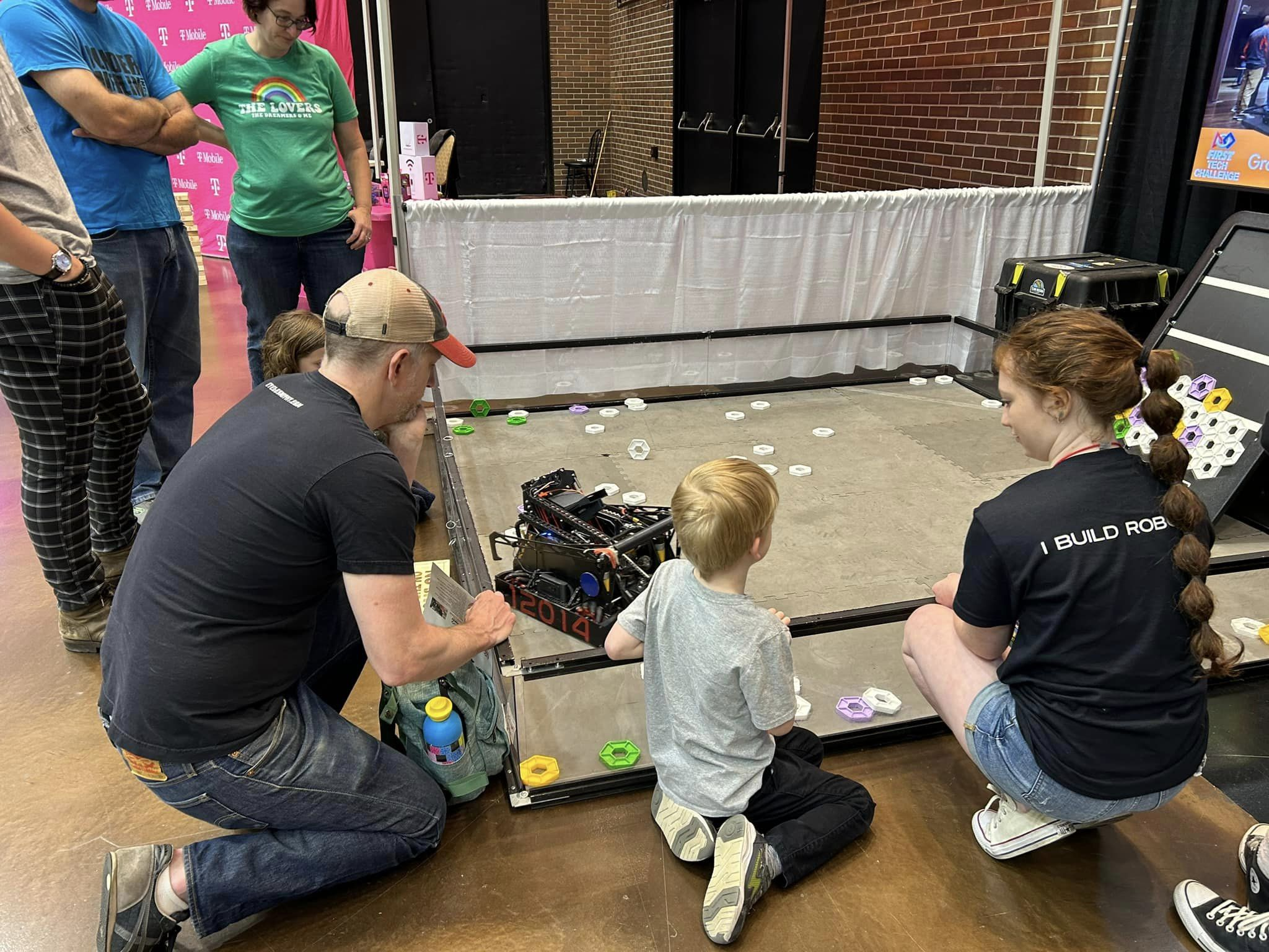 FireWires member Payton demonstrates the competition robot to youngster